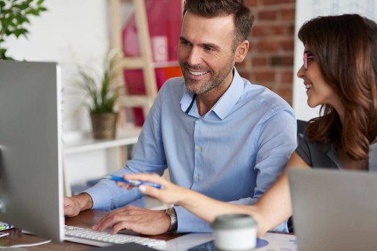 Persone al computer in ufficio che lavorano in modo più ordinato grazie all’integrazione tra InnovaCRM e Passepartout Mexal